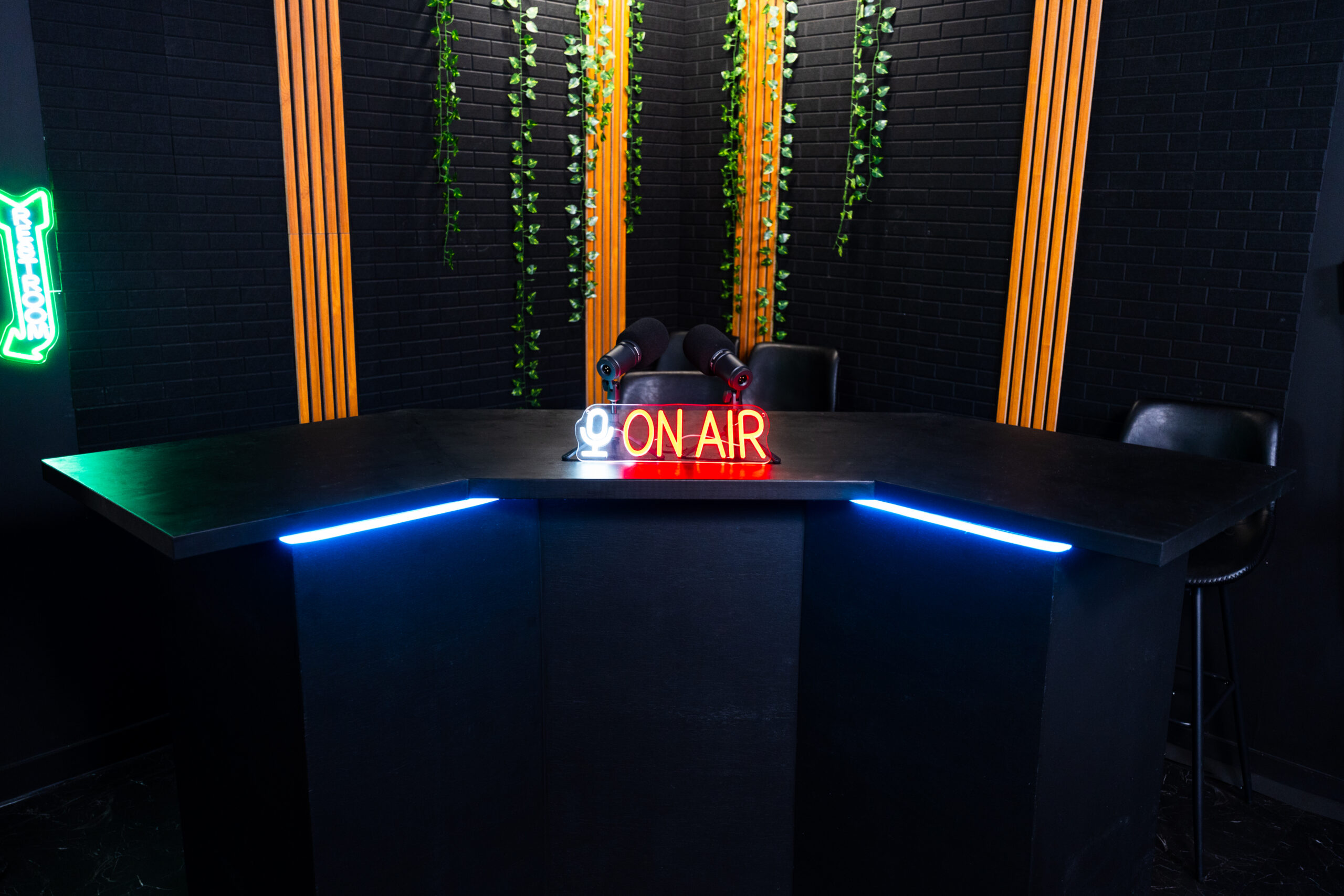 On air podcast desk with neon sign
